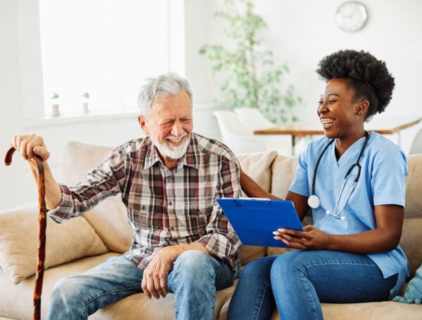 Nexus caregiver with senior man at home or nursing home